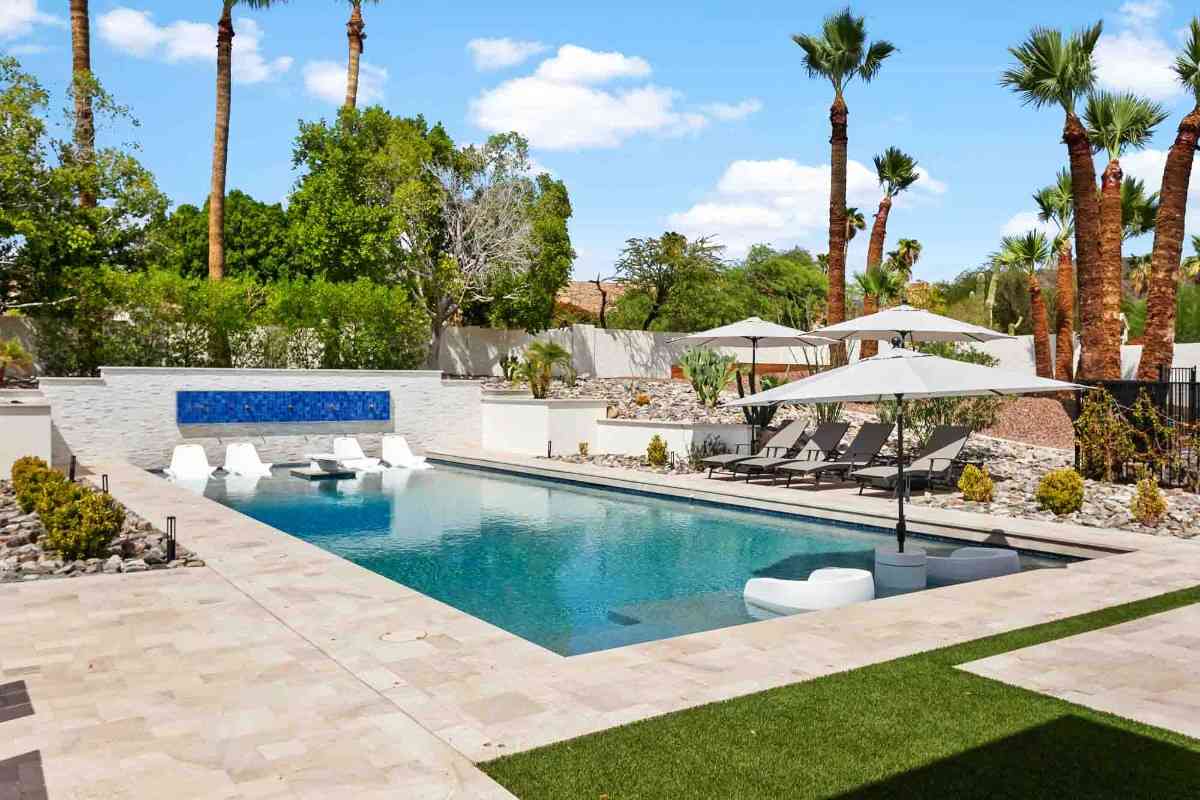 Spacious backyard with a central fire pit surrounded by white chairs