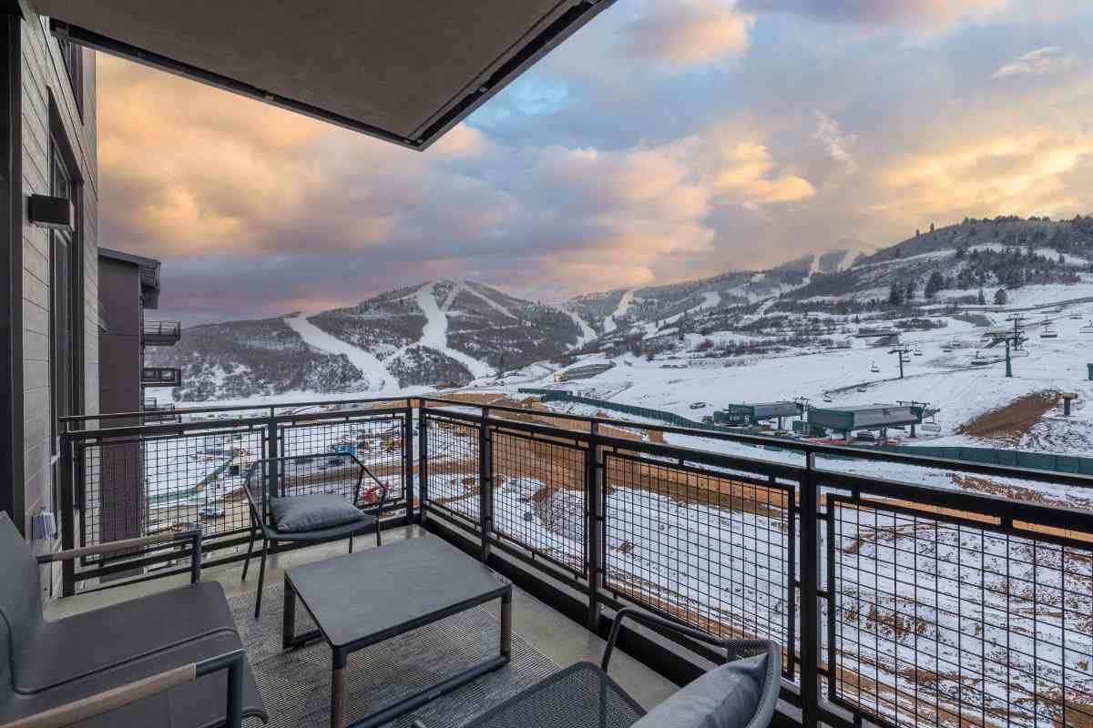 Balcony view of snow-covered mountains and ski slopes at sunset