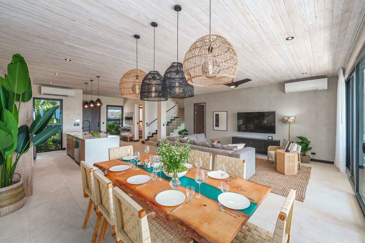 Modern open-plan living space with a rustic dining table set for six